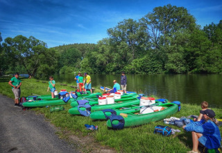 Famiglia che prepara canoe sulla riva del fiume al Camping Prima, parco vacanze in Boemia Meridionale, Repubblica Ceca.