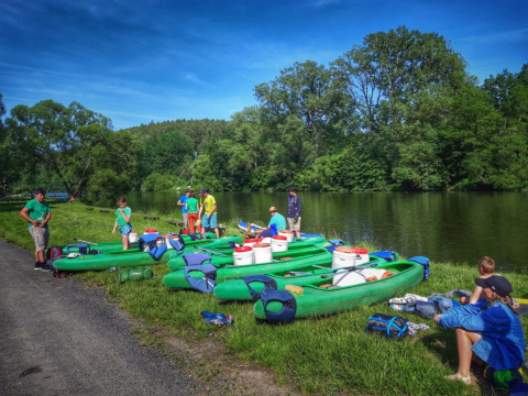 Famiglia che prepara canoe sulla riva del fiume al Camping Prima, parco vacanze in Boemia Meridionale, Repubblica Ceca.