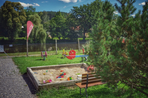 Spielplatz mit Sandkasten, Sitzbank und Spielgeräten bei Camping Prima im südlichen Böhmen, Tschechien.