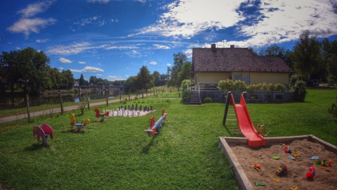 Spielplatz mit Rutsche, Sandkasten und Spielzeug bei Camping Prima, Südböhmen, Tschechien, bei einem Ferienhaus.