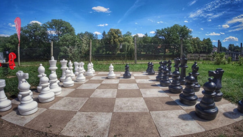 Ein überdimensionales Schachbrett mit großen Figuren im Freien bei Camping Prima, Südböhmen, Tschechien.