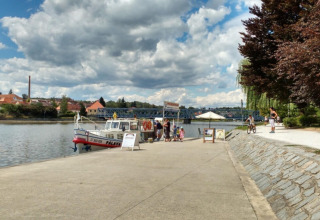 Bådeplads ved Camping Prima i Sydbøhmen, Tjekkiet, med folk ved vandet under en skyet himmel.