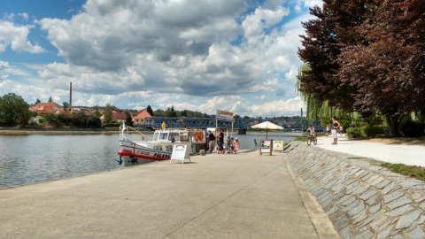 Bootsteiger aan Camping Prima in Zuid-Bohemen, Tsjechië, met gezinnen en wandelaars langs het water.