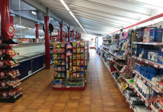 Innenansicht eines Supermarktes im Vilanova Park Campingplatz in Katalonien, Spanien mit Regalen voller Produkte.