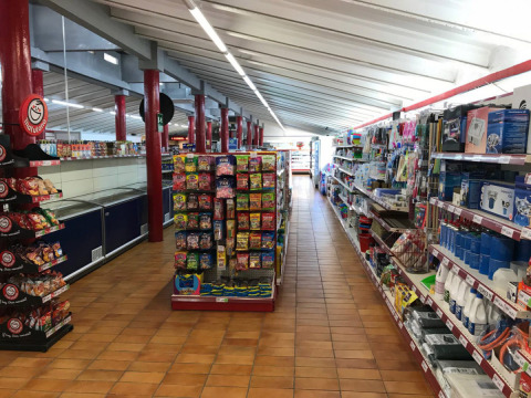 Binnenzicht van een supermarkt op Vilanova Park Camping in Catalonië, Spanje, met rekken vol producten.