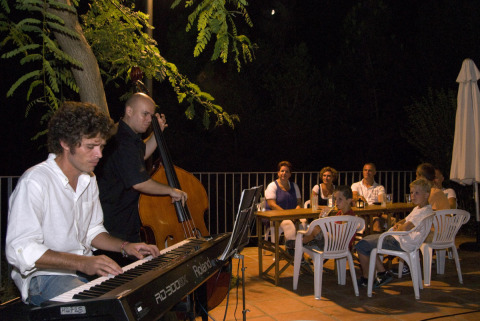 Actuación de música en vivo por la noche en el camping Vilanova Park, Cataluña, con huéspedes disfrutando afuera.