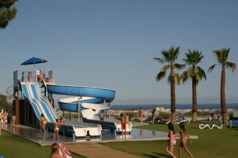Children enjoy a waterslide and pool at Vilanova Park Campsite, holiday resort in Catalonia, Spain.
