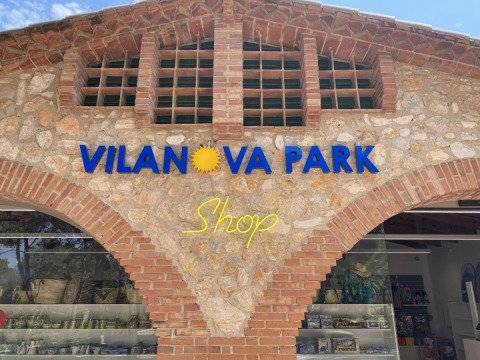 Winkelgevel met het bord 'Vilanova Park Shop' bij Vilanova Park Camping in Catalonië, Spanje.