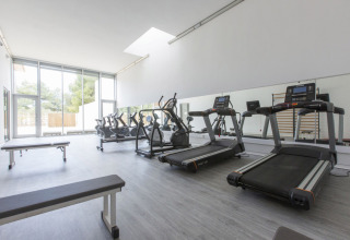 Salle de sport moderne au camping Vilanova Park en Catalogne, Espagne, avec tapis de course et appareils.