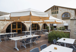 Espace extérieur avec parasols et tables au Vilanova Park Campsite, parc de vacances en Catalogne, Espagne.