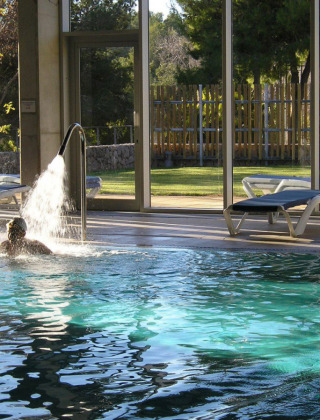 Indendørs swimmingpool med sollys og liggestole på Vilanova Park Campingplads i Catalonien, Spanien.
