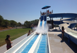 Kinderen spelen op de waterglijbanen in Vilanova Park Campsite, een vakantiepark in Catalonië, Spanje.