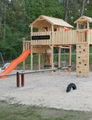 Parco giochi a Camping Sonnenberg, Bassa Sassonia, Germania con scivolo, altalene e parete da arrampicata.