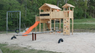 Aire de jeux au Camping Sonnenberg en Basse-Saxe, Allemagne, avec toboggan, balançoires et cabane.