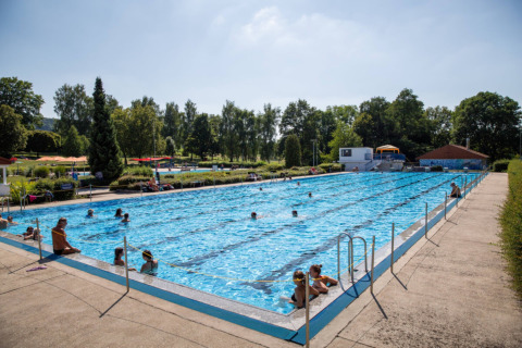 Piscina all'aperto con visitatori al Camping Walsheim, un villaggio vacanze in Saarland, Germania.