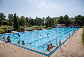 Piscina all'aperto con visitatori al Camping Walsheim, un villaggio vacanze in Saarland, Germania.