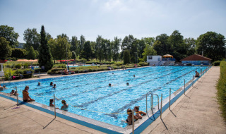 Piscina al aire libre con visitantes en Camping Walsheim, un parque vacacional en Saarland, Alemania.