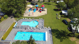 Vista aérea de Camping de Zeven Heuveltjes con piscinas, zona de juegos y césped en Drenthe, Países Bajos.