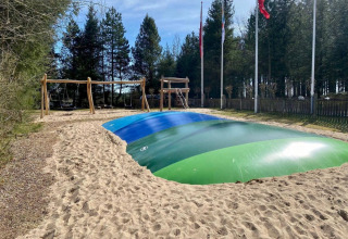 Grande cuscino gonfiabile per saltare e altalene nell’area giochi di Tolne Camping, Jutland del Nord, Danimarca.