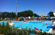 Piscina all'aperto affollata al Camping Tussen de Diepen, parco vacanze a Overijssel, Paesi Bassi.