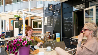 Zwei Frauen genießen Kaffee auf der Terrasse im Ferienpark Camping Tussen de Diepen in Overijssel.