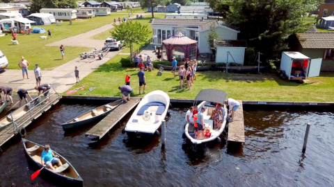 Parque de vacaciones Camping Tussen de Diepen en Overijssel, Países Bajos, con botes, canoas y familias junto al agua.