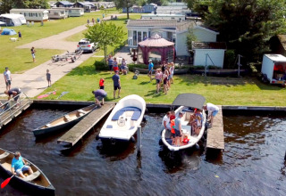 Holiday park Camping Tussen de Diepen in Overijssel, Netherlands with boats, canoes, and families by the water.