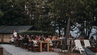 Cena al aire libre con luces y árboles en Camping Luna del Monte, parque de vacaciones en Umbría, Italia.