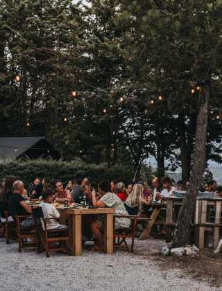 Cena al aire libre con luces y árboles en Camping Luna del Monte, parque de vacaciones en Umbría, Italia.