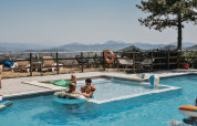 Famiglie che si rilassano in piscina con vista sulle colline al Camping Luna del Monte in Umbria, Italia.