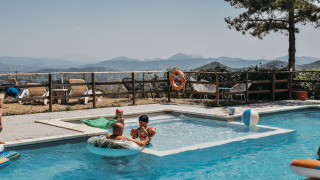 Gezinnen genieten van een zwembad met prachtig uitzicht bij Camping Luna del Monte in Umbrië, Italië.