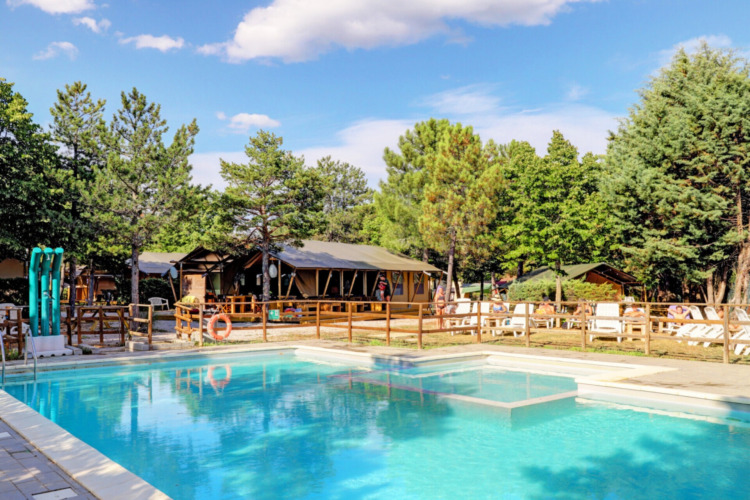 Pool und Liegestühle bei Camping Luna del Monte, einem beliebten Ferienpark in Umbrien, Italien.