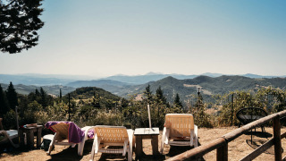 Ligstoelen met uitzicht op heuvels bij Camping Luna del Monte, een vakantiepark in Umbrië, Italië.