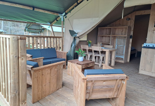 Tente safari avec mobilier en bois et terrasse couverte au Camping de Zeven Heuveltjes, Pays-Bas.