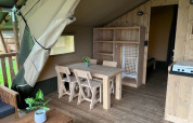 Interior de una tienda safari con instalaciones sanitarias en Camping de Zeven Heuveltjes, Países Bajos, muebles de madera.