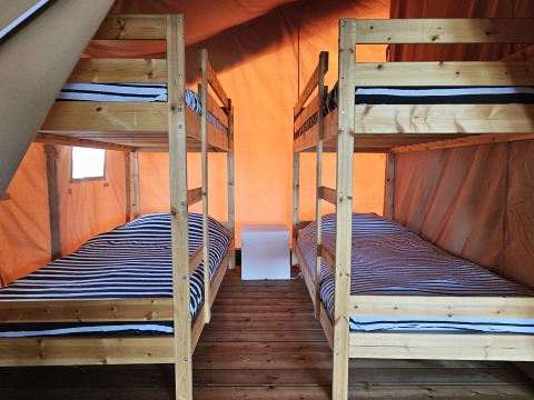 Indvendigt billede af Safari-teltet ved Camping Luna del Monte i Italien med to køjesenge i træ.
