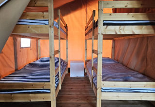 Vista interna della tenda Safari al Camping Luna del Monte in Italia, con due letti a castello in legno.