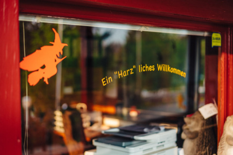 Ingang van Camping Braunlage met Duits welkomstbord en heksfiguur in Nedersaksen, Duitsland.