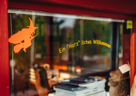 Ingang van Camping Braunlage met Duitse welkomsttekst en heksdecoratie in Nedersaksen, Duitsland.