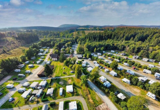 Vista aerea di Camping Braunlage in Bassa Sassonia, Germania, con roulotte e paesaggio verdeggiante di boschi.