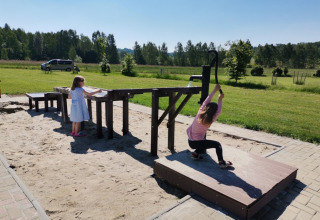 Børn leger med en vandpumpe i sandkassen på Camping de Regenboog, Ústí nad Labem, Tjekkiet, på en solrig dag.