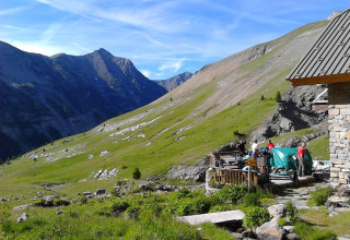 Bjergrigt landskab ved Camping Lou Passavous, Provence-Alpes-Côte d’Azur, Frankrig, med folk udendørs.