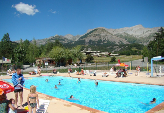 Udendørs swimmingpool på Camping Lou Passavous i Provence-Alpes-Côte d’Azur med bjergrig baggrund.