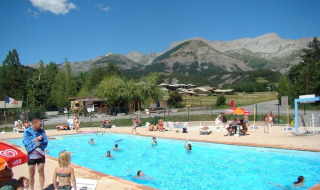 Udendørs swimmingpool på Camping Lou Passavous i Provence-Alpes-Côte d’Azur med bjergrig baggrund.