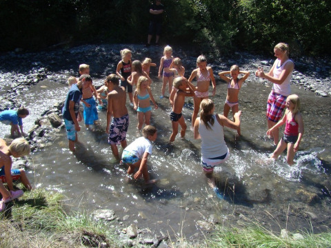 Niños jugando en el agua poco profunda bajo el sol en Camping Lou Passavous, Provence-Alpes-Côte d’Azur.