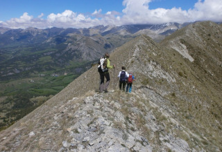 Escursionisti camminano su una cresta di montagna in Provenza-Alpi-Costa Azzurra, Francia, con ampio panorama.