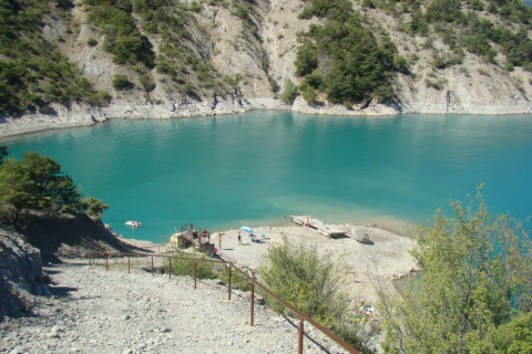 Lago azzurro circondato da colline rocciose al Camping Lou Passavous in Provenza-Alpi-Costa Azzurra.