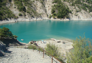 Blick auf einen türkisblauen See und felsige Ufer bei Camping Lou Passavous in der Provence-Alpes-Côte d’Azur.