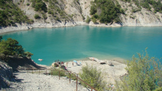 Lago azzurro circondato da colline rocciose al Camping Lou Passavous in Provenza-Alpi-Costa Azzurra.
