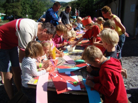 Niños y adultos haciendo manualidades al aire libre en Camping Lou Passavous, Provenza-Alpes-Costa Azul, Francia.
